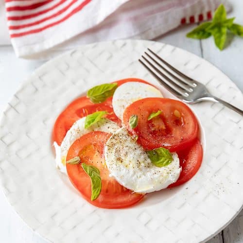 La recette traditionnelle de la salade caprese, tomates, mozzarella et basilic.