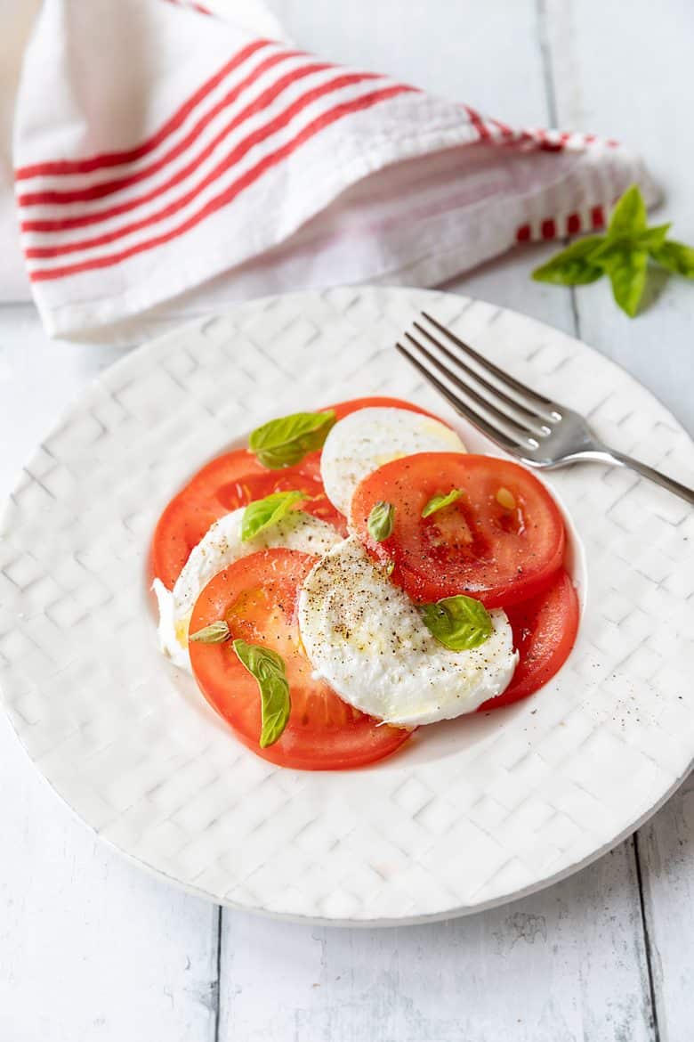 La recette traditionnelle de la salade caprese, tomates, mozzarella et basilic. 