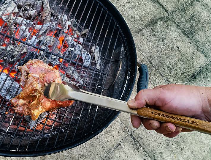 Barbecue, les braises sont blanches, on dépose la viande sur le côté à l'aide de pince à viande
