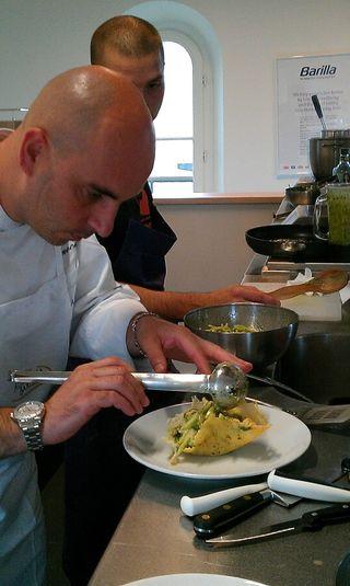 Marcello Zaccaria dresse les pâtes dans un bol de parmesan