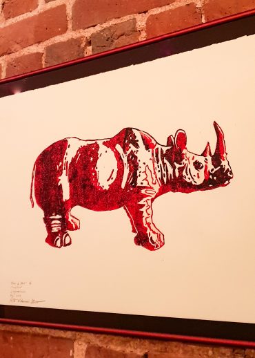 Restaurant Rhino Rouge, tableau à l'encre rouge représentant un rhinocéros rouge