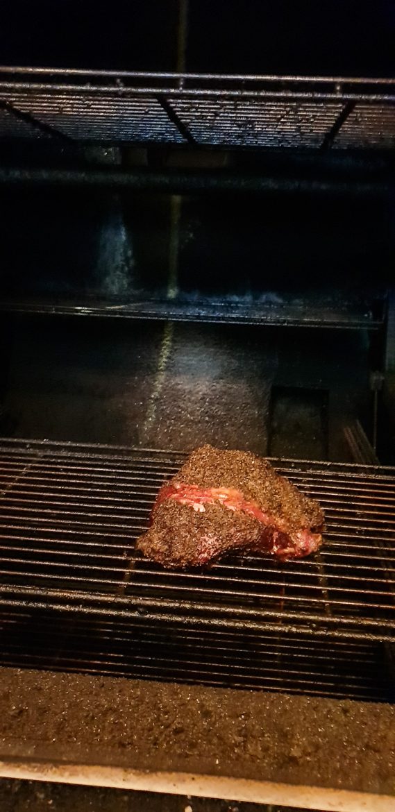 Une pièce de viande en train de cuire dans l'oyler pit du rhino Rouge