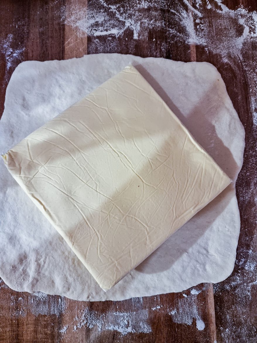La pâte feuilletée pas-à-pas : déposer le carré de beurre sur la détrempe