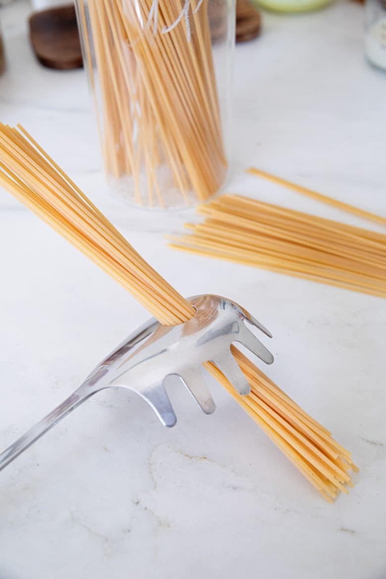 Spaghetti mesurées avec la cuillère à pâtes. 